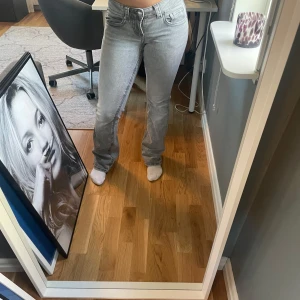 Grå jeans med bootcut - Snygga grå jeans med bootcut-stil och låg midja. Perfekta för en avslappnad look. De har klassiska fem fickor och en dragkedja med knapp framtill.