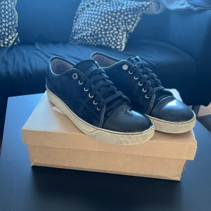 Lanvin  - Snygga mörkblåa sneakers från lanvin med snörning och en stilren design. Skorna har en vit sula som ger en fin kontrast till det blåa. Perfekta för en avslappnad stil. Endast skorna medföljer. Pris hugget i sten