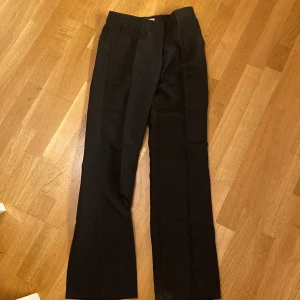 Svarta kostymbyxor från Nelly - Snygga svarta kostymbyxor från Nelly med en klassisk design. Byxorna har en rak passform och är perfekta för en stilren look. Har bara använt 1 gång men dom satt lite konstigt på mig och var för långa, priset kan diskuteras 