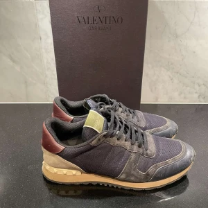 Valentino Rockrunners - Snygga Valentino Rockrunner sneakers i en mix av svart och mörkröd med beige detaljer. Storlek 43,5, LÅDA och 2 DUSTBAGS INGÅR. Pris kan diskuteras. Mvh.