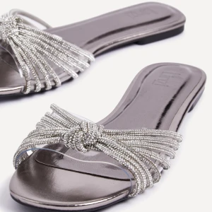 Glittriga silvriga sandaler - Snygga sandaler i silver med glittrande pärldetaljer. Helt nya och oanvända, säljer pga för små i storleken. 