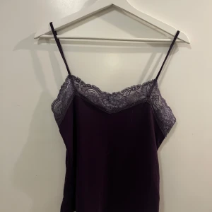 Lila linnetopp med spetsdetaljer från Bik Bok - Säljer lila spetslinne från Bik Bok med tunna axelband och V ring💜