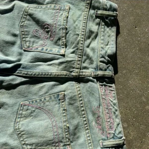 Ljusblå jeans med rosa detaljer🎀 - Snygga ljusblå jeans med broderad detalj på bakfickorna. De har en låg midja och smygga detaljer💓 Innerbenslängd är 84 cm och midjemått rakt över är ca 37 cm💗 Skriv vid fler frågor och funderingar!💕