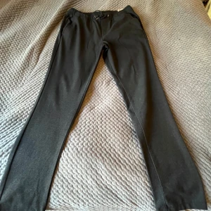 Svarta byxor från Jack & Jones - Snygga svarta byxor från Jack & Jones med elastisk midja och dragsko. Perfekta för en avslappnad stil. Byxorna har en rak passform och är tillverkade i ett mjukt material för extra komfort.