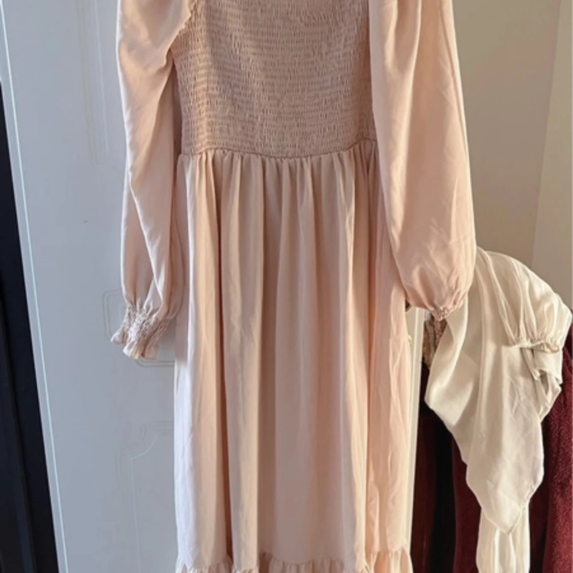 Ljusrosa långklänning med smockdetaljer