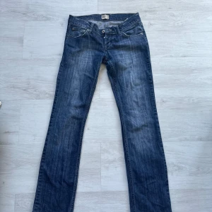 Blå jeans från Tommy Hilfiger - Snygga blå jeans från Tommy Hilfiger. Lite kortare än de vanliga jeans som motsvarar storlek S men väldigt sköna och mjuka i materialet för att vara jeans. Knapptgylf och fina mönster av märket.  Finns i djur/ rökfritt hem, skickas mot fraktkostnad. Använda men fint skick!! 350kr + en frakt. 