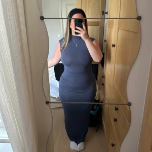 Topp och kjol  - Snygg mörkgrå / blå  kjol och topp med ärmlös design och hög hals. Settet har en tight passform som framhäver figuren. Perfekt för en stilren och elegant look. Kjol & topp o storlek S