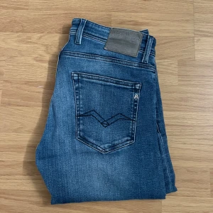 Blå jeans från Replay - Snygga blå jeans från Replay i modellen Grover. De har en klassisk femficksdesign och en bekväm passform. Perfekta för en avslappnad stil med en touch av trend.