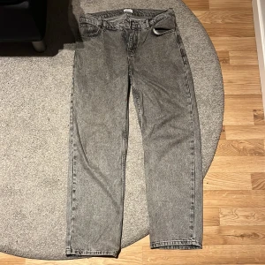 Grå jeans från Grunt - Säljer ett par grå jeans från Grunt i en klassisk straight fit. De har en normal passform med fem fickor och knappgylf. Perfekta för en avslappnad stil.