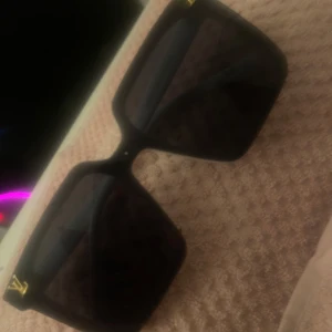 Svarta och vita solglasögon - Snygga solglasögon med fyrkantiga svarta linser och bågar i både svart och vitt. Detaljer i guld på sidorna ger en lyxig touch. Perfekta för en stilren look.