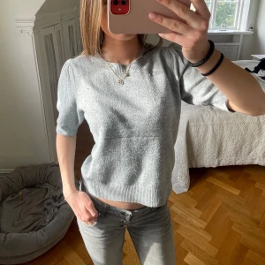 Grå tröja från ONLY - Säljer en stilren grå tröja från ONLY. Tröjan har korta ärmar och en ribbad kant vid ärmslut och nederkant. Perfekt för en avslappnad look. 🩶