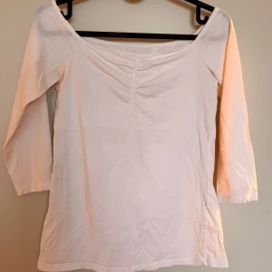 Vit topp med trekvartsärmar - Söt och enkel vit topp med trekvartsärmar och lätt rynkning vid bysten som ger en fin passform. Stretchigt och mjukt material som är bekvämt att bära. Passar perfekt till både vardag och lite mer uppklädda tillfällen. Använd endast ett fåtal gånger!