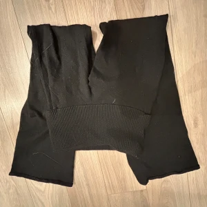 Svarta byxor från Gina Tricot - Snygga svarta byxor från Gina Tricot med en bred ribbad midja. Perfekta för en stilren look och bekväma att bära hela dagen. Jätte sköna stickade byxor