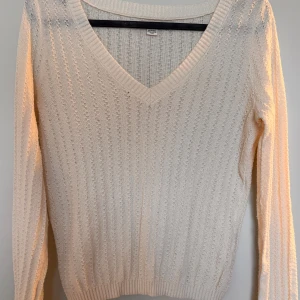 Långärmad V-ringad tröja - Krämfärgad långärmad V-ringad tröja med texturerad stickning. Mjukt och lätt material. Använd ett fåtal gånger. 