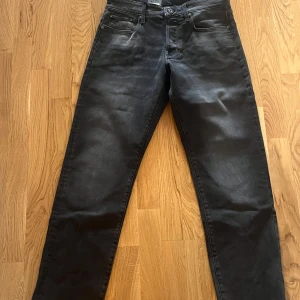 Svarta jeans från G-Star RAW - Snygga svarta jeans från G-Star RAW med en klassisk femficksdesign. De har en normal passform och är perfekta för en stilren look. Jeansen har en knappgylf och är tillverkade i ett slitstarkt material. W29/L34. Oanvända, lapp kvar