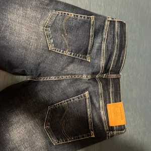 Mörkblå jeans från Jack & Jones - Snygga mörkblå jeans från Jack & Jones med en klassisk femficksdesign. De har en normal passform och är tillverkade i slitstarkt denim. Perfekta för en avslappnad stil. Bred 31 längd 34 mini hål på knät syns inte! 