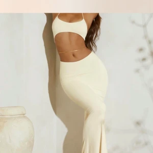 Oh Polly Vit långklänning med cut-out detaljer - Snygg vit långklänning med trendiga cut-out detaljer och smala axelband. Perfekt för en somrig look. Klänningen har en tight passform som framhäver figuren. Storlek XS, säljs ej längre från Oh Polly, som nu endast använd 2 gånger 