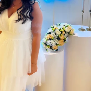 Vit ärmlös klänning - Säljer en elegant vit ärmlös klänning med v-ringning. Klänningen har en luftig kjol med flera lager och ett brett midjeband som ger en smickrande passform. ⚠️161 cm lång⚠️ använd 1 gång.