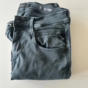 Grå jeans från Replay - Snygga grå jeans från Replay i modellen Anbass. Jeansen är använda men är fortfarande i bra skick!