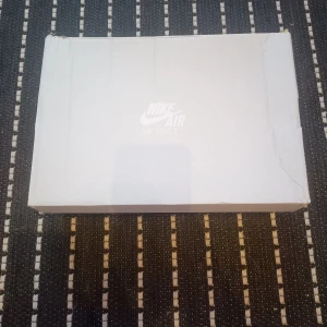 Vita Nike Air Force sneakers - Säljer ett par klassiska vita Nike Air Force sneakers. De har en stilren design med snörning och perforerade detaljer på ovansidan för extra ventilation. Perfekta för en casual look.