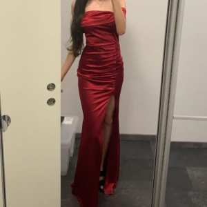 Röd balklänning - Säljer en röd balklänning i storlek 34. Materialet har en glansig satin finish. Klänningen är använd 2h och är därför i väldigt bra skick❤️ hör gärna av dig för frågor eller bilder