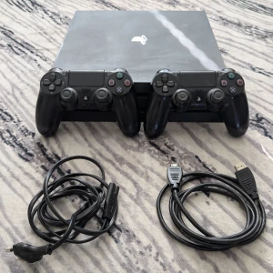 PlayStation 4 Pro med två kontroller - Säljer en PlayStation 4 Pro med två svarta DualShock 4-kontroller. Konsolen har en stilren design med PS4-logotypen på toppen. Inkluderar HDMI-kabel och strömkabel. Perfekt för gamingkvällar med vänner! 🎮 Kommer med två kontroller den till höger från första bilden är normal och den till vänster har stick drift. På toppen av Ps4 är den lite repig men det märks inte. Om de är något så är de bara att kontakta mig så löser vi något, mer bilder eller om pris bara och skriva 😊👍🫡