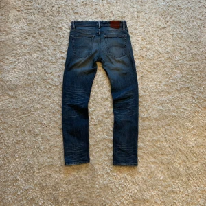 Tommy hilfiger jeans - Feta jeans från Tommy Hilfiger, de är använda men i mycket bra skick och har snygg fade och slitningarna. De enda defekterna jag kan hitta syns på de två sista bilderna och är mycket små fläckar. Enligt mig syns de knappt om man  inte kollar väldigt noga men du får avgöra själv med hjälp av första bilden. Storlek W31 L32!