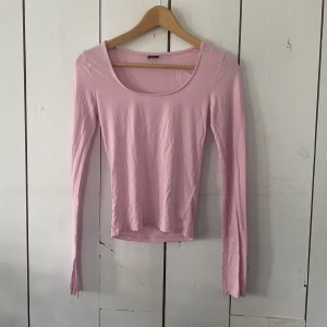 Ljusrosa långärmad topp Gina Tricot XS - Supersöt ljusrosa långärmad topp från Gina Tricot i stretchig bomull. Modellen är slim och har en rundad urringning samt cool slitsdetalj vid ärmsluten. Perfekt att styla med jeans eller kjol för en fräsch look.