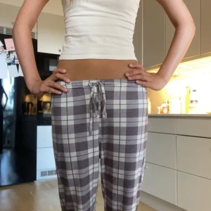 Rutiga mjukisbyxor med snörning - Säljer ett parsupet mjuka rutiga mjukisbyxor i grått och vitt med dragsko i midjan. Byxorna har en avslappnad passform och är perfekta för chill dagar hemma. Mjukt material och elastisk midja för extra komfort.😍🤍