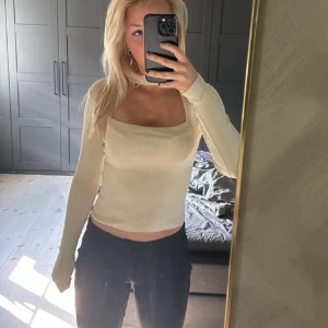 Topp från Zara - Säljer en beige chockertopp från Zara med fyrkantig urringning och ribbad struktur. Modellen är croppad och sitter snyggt med en slim passform. Perfekt att matcha med jeans eller kjol för en clean och fräsch look💞