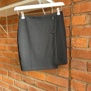 Svart kort kjol - Säljer denna dina kjol då jag ej använt den.  Den är antingen från only eller hm! Kjolen har samma material som kostymbyxor och har dragkedja baktill.