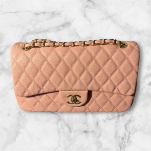 Råsa chanel väska i skin  - Denna Chanel-väska är 30 cm bred och 17 cm hög, vilket gör att du får plats med mycket i den. Kedjan är mycket bekväm att bära och går att justera i längd så att den passar dig perfekt.