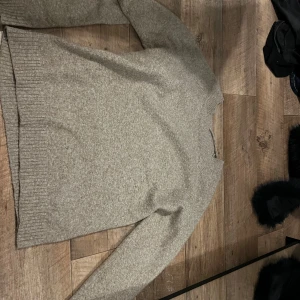 Beige stickad tröja från Vero Moda - Mysig beige stickad tröja från Vero Moda i storlek XS. Tröjan har en klassisk rund halsringning, ribbade muddar och lång ärm. Perfekt för lager-på-lager och chill dagar. Enkel att matcha med jeans eller kjol.
