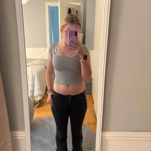 Ljusgrå  topp  - Supersnygg ljusgrå topp från new yorker med korta ärmar och silverfärgad kedjedetalj vid halsringningen. Toppen har en slim passform och är stretchig. Jag skulle säga att tröjans storlek igentligen skulle vara XS/S men det står M på lappen.