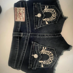 True Religion jeansshorts  - Mörkblå jeansshorts från True Religion med snygga broderade bakfickor och råa, fransiga kanter. 