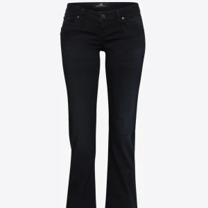 Svarta bootcut jeans från LTB - Snygga svarta jeans från LTB med bootcut passform. Jeansen har klassisk femficksdesign, låg midja och är tillverkade i stretchig denim för en bekväm känsla. Perfekta för dig som gillar en tidlös look med lite utsvängda ben. Dem är lite slitna längst ner men annars i riktigt bra skick!