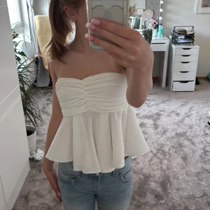 Vit bandeau tubtopp med volang - Supersöt vit bandeau tubtopp med volangig, utsvängd nederdel och rynkade detaljer framtill. Säljer då den inte kommit till användning💗