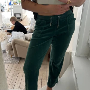 Mörkgröna mjukisbyxor Juicy Couture - Ett par mjukisbyxor från juicy couture i mörkgrön färg. Säljer för att de är lite korta. Bra skick, perfekta till mjukisbyxor, vanliga byxor eller som överdragsbyxor. Säljer även tröjan till💗