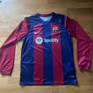 Barcelona fotbollströja - Longsleeve barcelona fotbollströja från säsong 23/24. Säljer då den nästan aldrig kommit till användning, alltså mycket bra skick! Skriv vid funderingar! 