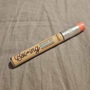 Benefit Boi-ing Bright On Concealer - Boi-ing Bright On Concealer från Benefit i en beige tub med silver- och korallfärgat lock. Perfekt för att ljusa upp under ögonen och täcka mörka ringar. Smidig penna med 5 ml produkt, enkel att ta med i väskan.