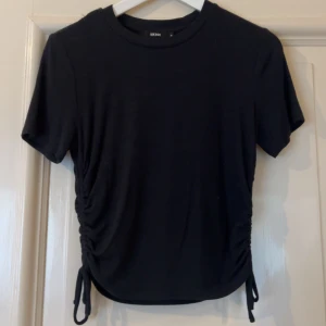 Svart ribbad topp, snörning - Svart ribbad topp från Bik Bok med korta ärmar och rund hals