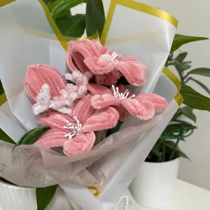 Rosa blombukett  - Bilderna visar en bukett med rosa och vita blommor gjorda av piprensare, inslagna i vitt papper med guldkant. Konstgjorda blommor som kan användas som dekoration eller present.