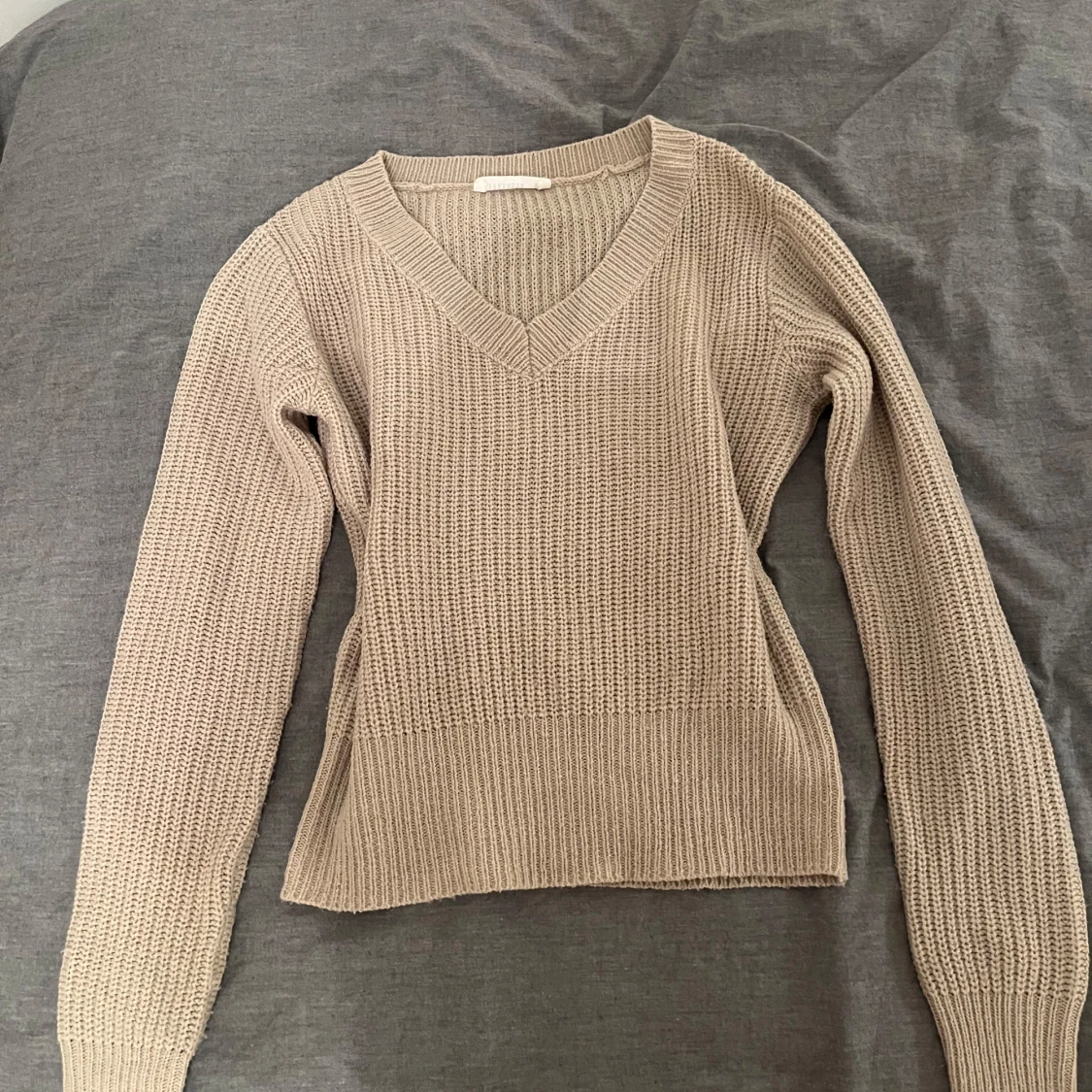 Stickad tröja med v-ringning