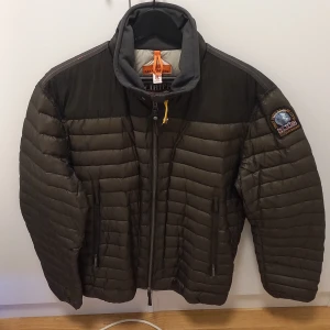 Parajumpers Daytripper dunjacka XL - Säljer en olivgrön Parajumpers Daytripper dunjacka i storlek XL. Jackan har quiltad design, hög krage, dragkedja framtill och två sidofickor med dragkedja. Klassisk PJS-patch på ärmen och orange detalj i nacken. Perfekt för kyligare höst dagar. Jackan har jag använt en enda gång eftersom att den är för liten för mig. Jackan skulle jag säga är helt ny! Kostade 5999kr i affären. 