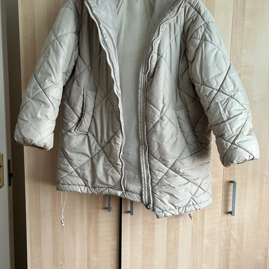 Beige quiltad pufferjacka med huva