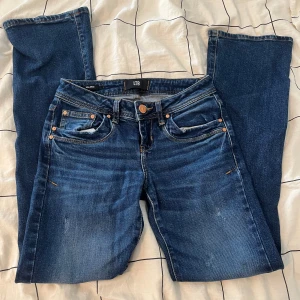 Lågmidjade flared jeans från LTB - Snygga mörkblå jeans från LTB med klassisk femficksdesign och kontrastsömmar. Jeansen har lite utsvängda ben och normal passform, tillverkade i slitstarkt denimtyg. Säljer då jag inte får användning av dom! Obs materialet e inte så stretchiga på dessa jeans. STORLEK: w24/L30