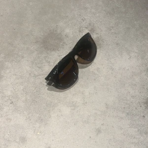 Bruna Ray-Ban solglasögon, fyrkantig - Snygga fyrkantiga solglasögon från Ray-Ban med brunt, transparent skal och bruna polariserade glas. Klassisk logga på sidan och tillverkade i Italien. Perfekta för dig som vill ha en skön och stil rena brillor. Pris kan diskuteras. Hör av er!