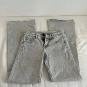 Grå lågmidjade utsvängda jeans - Snygga ljusgrå lågmidjade bootcut flare jeans. Helt nya aldrig använt.