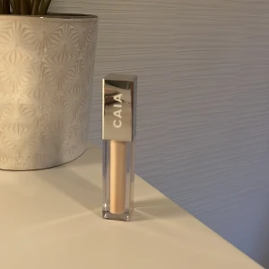 CAIA concealer 1W - Concealer från CAIA i en ljus beige nyans. Kommer i en stilren fyrkantig förpackning med silvrigt lock och applikator. Perfekt för att täcka mörka ringar eller blemmor. Enkel att applicera tack vare den mjuka borsten. Svårt o visa hur mycket som finns kvar men den är ej använd så mycket.