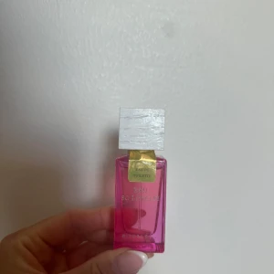 Rituals Eau So Lovely parfym - En snygg parfymflaska från Rituals i modellen Eau So Lovely. Flaskan är rektangulär i genomskinligt rosa glas med en vit fyrkantig kork och gulddetaljer. Perfekt för dig som gillar fräscha och feminina dofter.